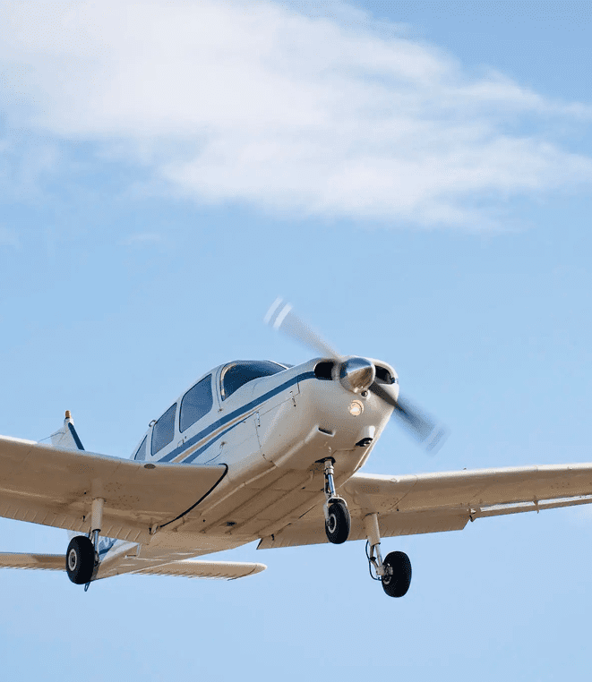 Small single-engine airplane flying against a blue sky.